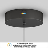 A black ceiling light fixture with a visible color temperature switch and colored indicators, mounted on a white ceiling. Below is a label in English, French, and Spanish about the color temperature switch.