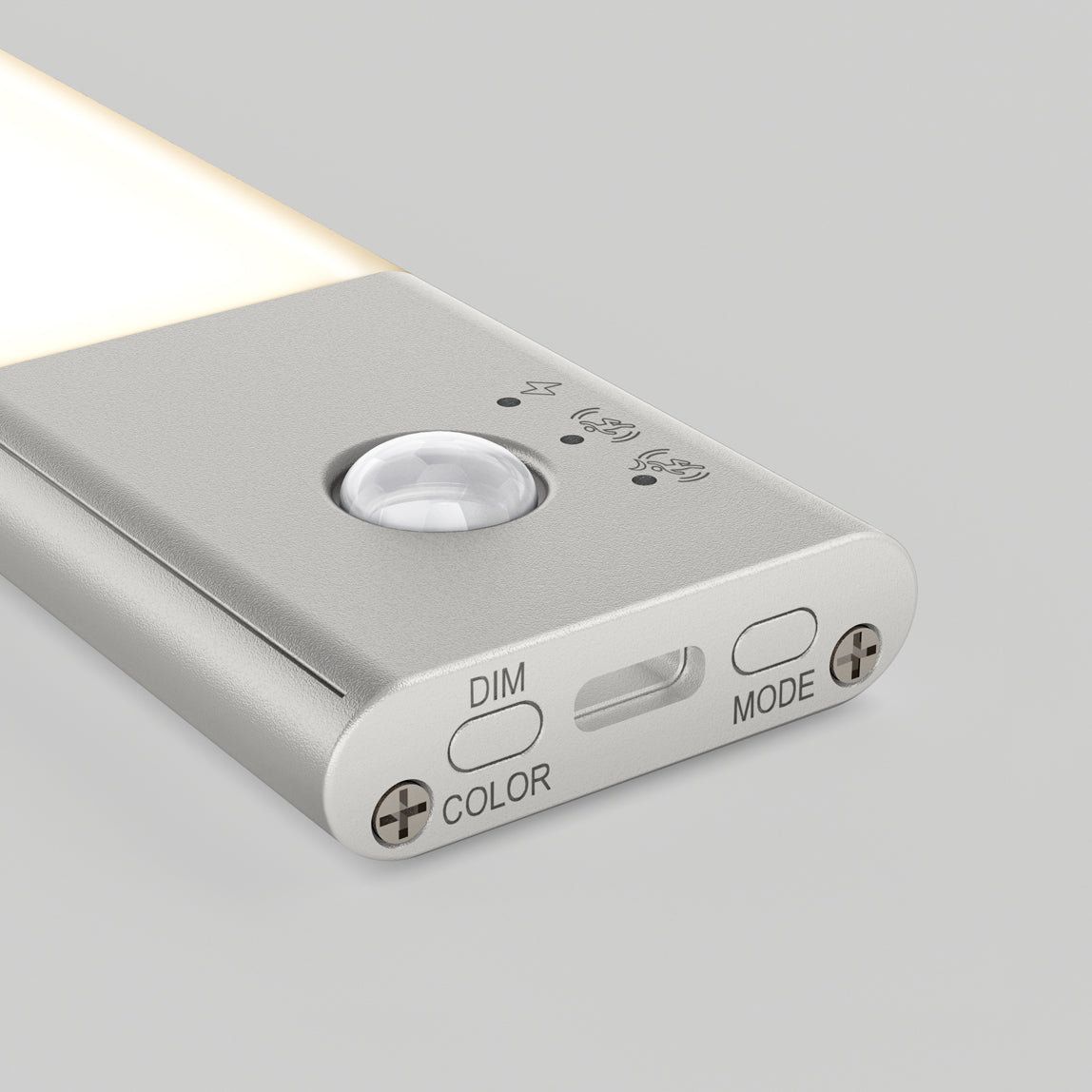 A close-up of a slim, silver LED light with a motion sensor, indicator icons, and three buttons labeled “DIM,” “COLOR,” and “MODE” on one end, set against a light gray background.