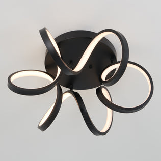 The Artika Swirl Ribbon flush mount light features black looping LED strips that emit a soft white glow, mounted on a circular base against a plain white ceiling.
