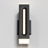A modern, rectangular wall sconce with a black frame and glowing white light strip in the center, mounted on a light gray wall.
