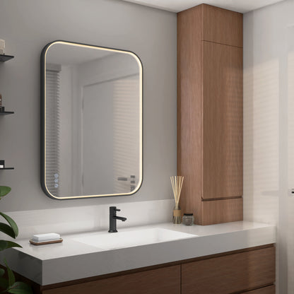 A minimalistic bathroom features the Artika Royce dimmable LED mirror 3 CCT above a white sink with a black faucet, wooden cabinets, and a reed diffuser, creating an organized, contemporary space.