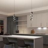 Modern kitchen with a white island, two gray chairs, and unique spiral pendant lights. Cabinets are white and gray, with open shelves, a stove, and a tiled backsplash. The space is tidy and well-lit.