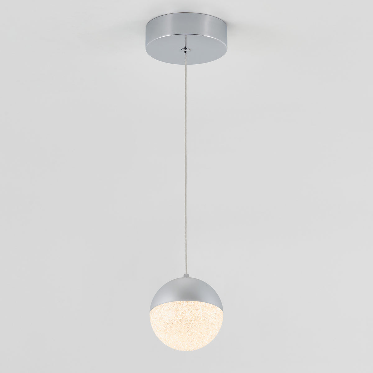 The Artika Sparkle 1 light LED pendant features a round, textured white globe suspended by a slim cord from a circular silver ceiling mount, shown against a plain white background.