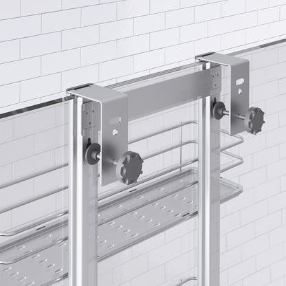 Close-up of the Artika Camden Shower Caddy, a modern glass shower door organizer with metal brackets and knobs, plus a metal shelf and towel rail mounted below the brackets on a tiled bathroom wall.