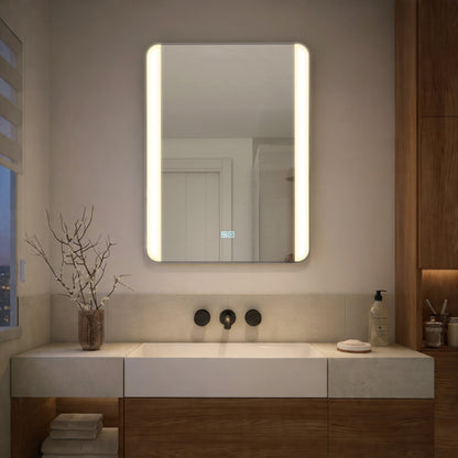 Modern bathroom with Artika Onyx LED Mirror with Defogger, sink, chrome faucets, soap dispenser, and a decorative branch in a vase.