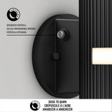 Close-up of a black outdoor light fixture showing its integrated photocell sensor. Text highlights Dusk to Dawn functionality in English, French, and Spanish, with icons and descriptions of the photocell feature.