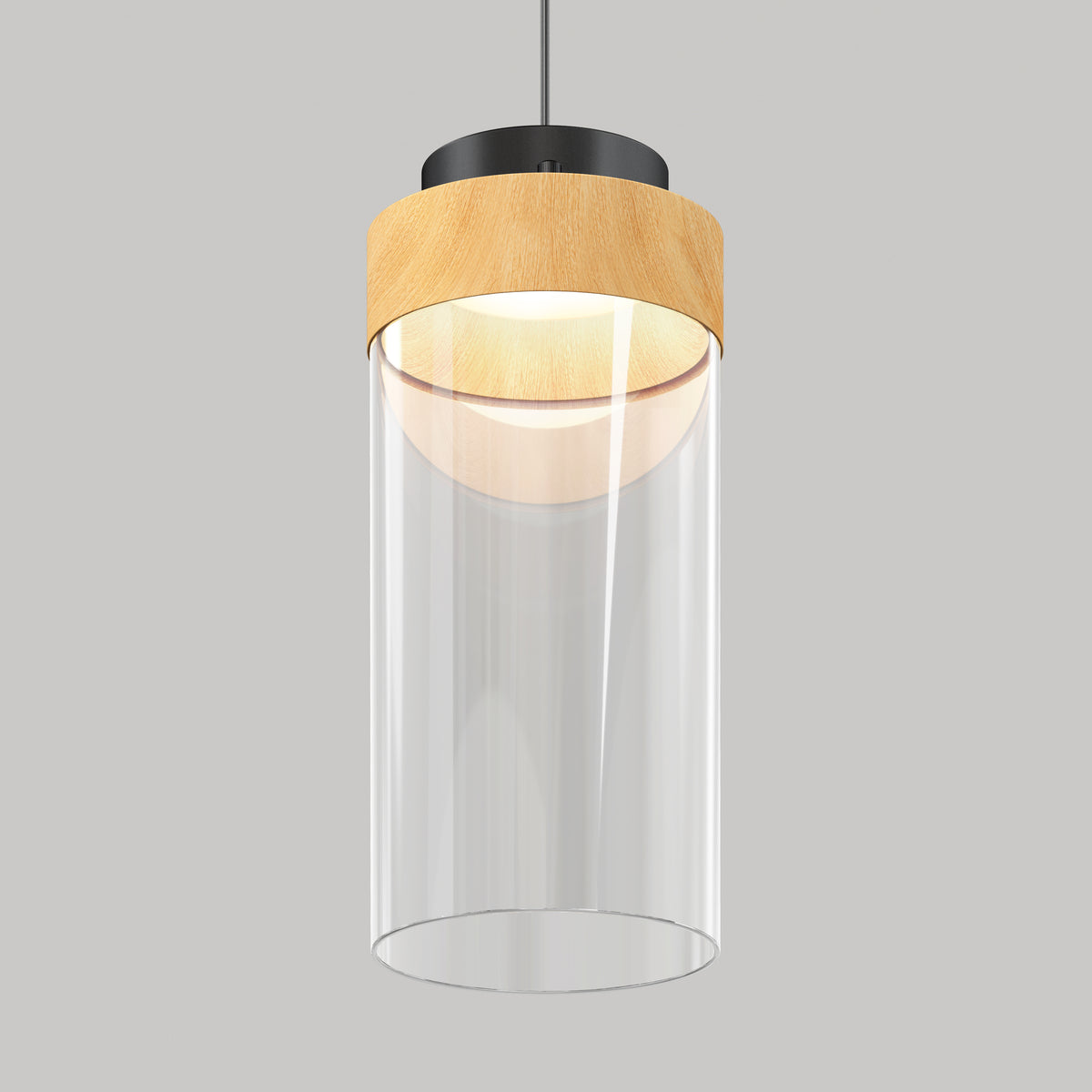 A modern pendant light with a cylindrical clear glass shade, a wooden accent at the top, and a black metal fixture, suspended against a plain gray background.