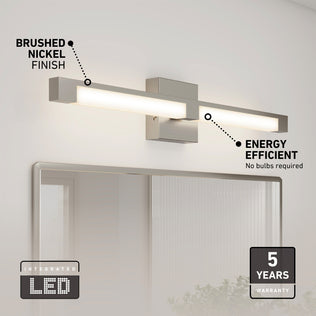 The Artika Tivoli modern LED bathroom vanity light 5 CCT in brushed nickel is mounted above a mirror. Text notes its energy efficiency, integrated LED, and adjustable lighting. A 5-year warranty badge is shown in the bottom right corner.