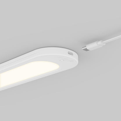 Artika Impulse Under-Cabinet LED Light RGB+CCT with Remote on gray surface, white USB-C cable near the charging port.