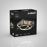 A black box with Artika Luxury+ branding displays a modern LED ceiling light with geometric ring designs, glowing with warm light. Product details and icons are shown on the packaging.