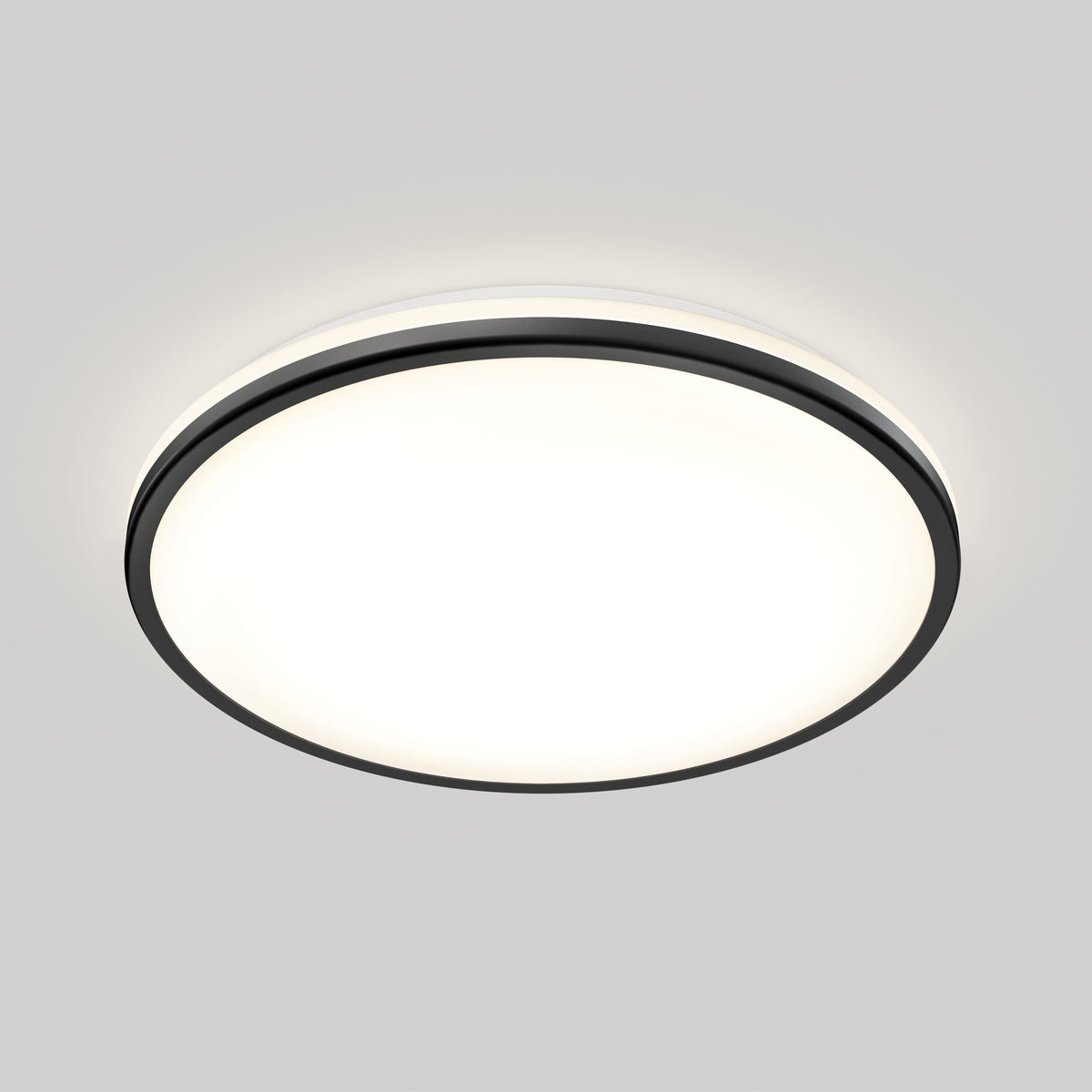 Round, flush-mounted ceiling light fixture with a black rim, glowing brightly against a plain white ceiling.