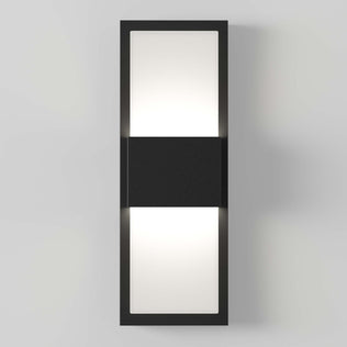 The Artika Mazza Frosted indoor-outdoor LED wall light features a modern rectangular black frame with a central black section, casting light from the top and bottom against a light gray wall.