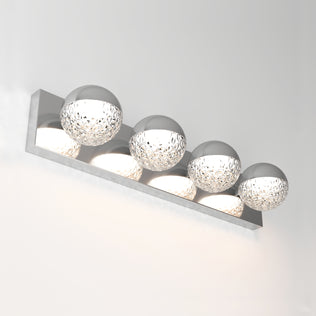The Artika Carat 27-in (69 cm) Integrated LED Vanity Light Bar for Bathrooms features four textured spherical glass lamps on a sleek chrome rectangular base, creating a modern touch against a plain white wall.