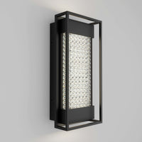 The Artika Glam indoor-outdoor LED wall light features a black metal frame and textured illuminated glass center, creating a modern look on any light gray wall.