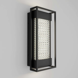 The Artika Glam indoor-outdoor LED wall light features a black metal frame and textured illuminated glass center, creating a modern look on any light gray wall.