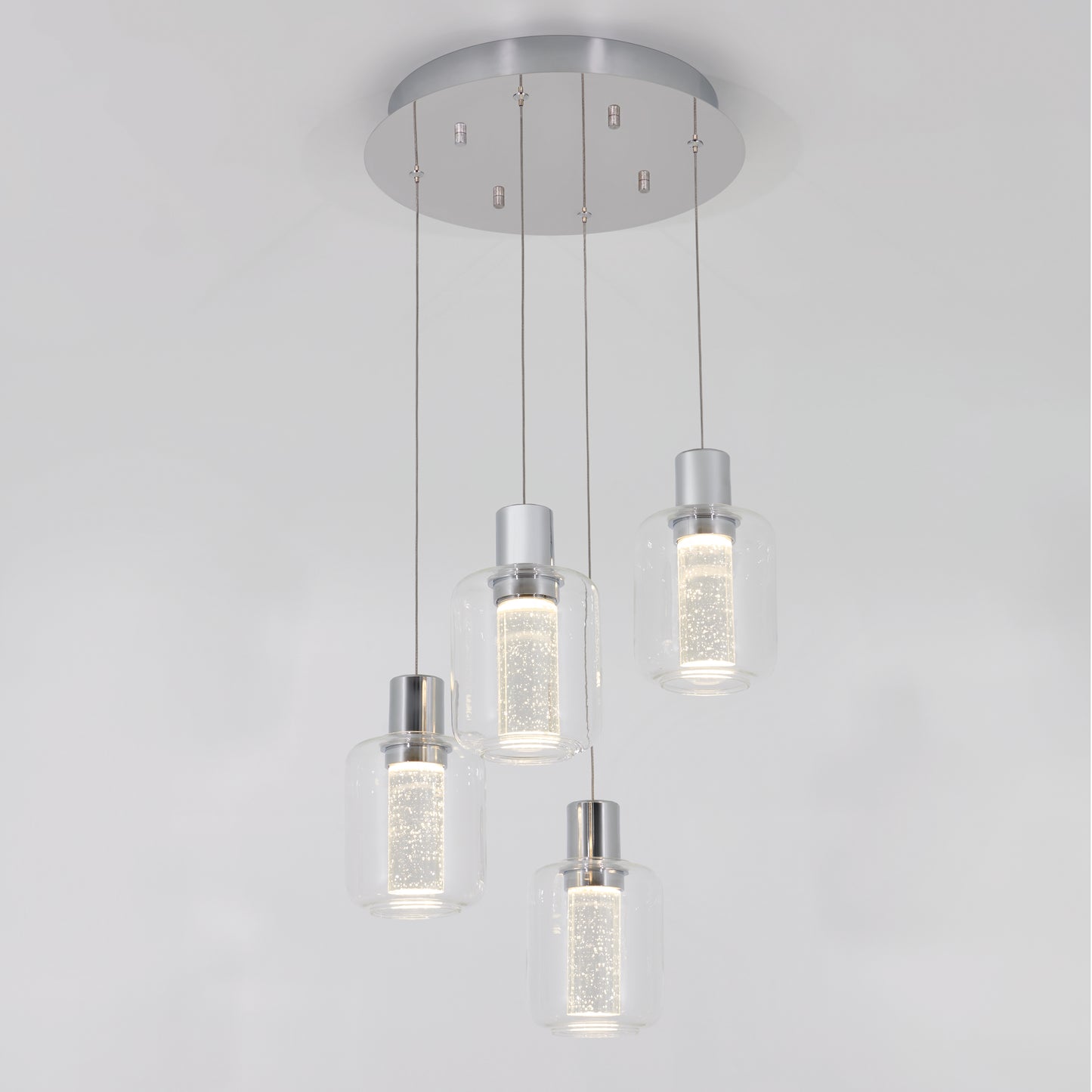 The Artika Champagne Globe 4-light LED pendant features four cylindrical glass shades with inner textured detail, suspended from a round metallic base, creating a modern ceiling light fixture.