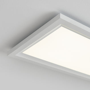 A close-up of the Artika Sunray ultra thin LED light panel 3 CCT, a modern rectangular ceiling fixture with a white frame, mounted on a white ceiling and emitting bright, even light.