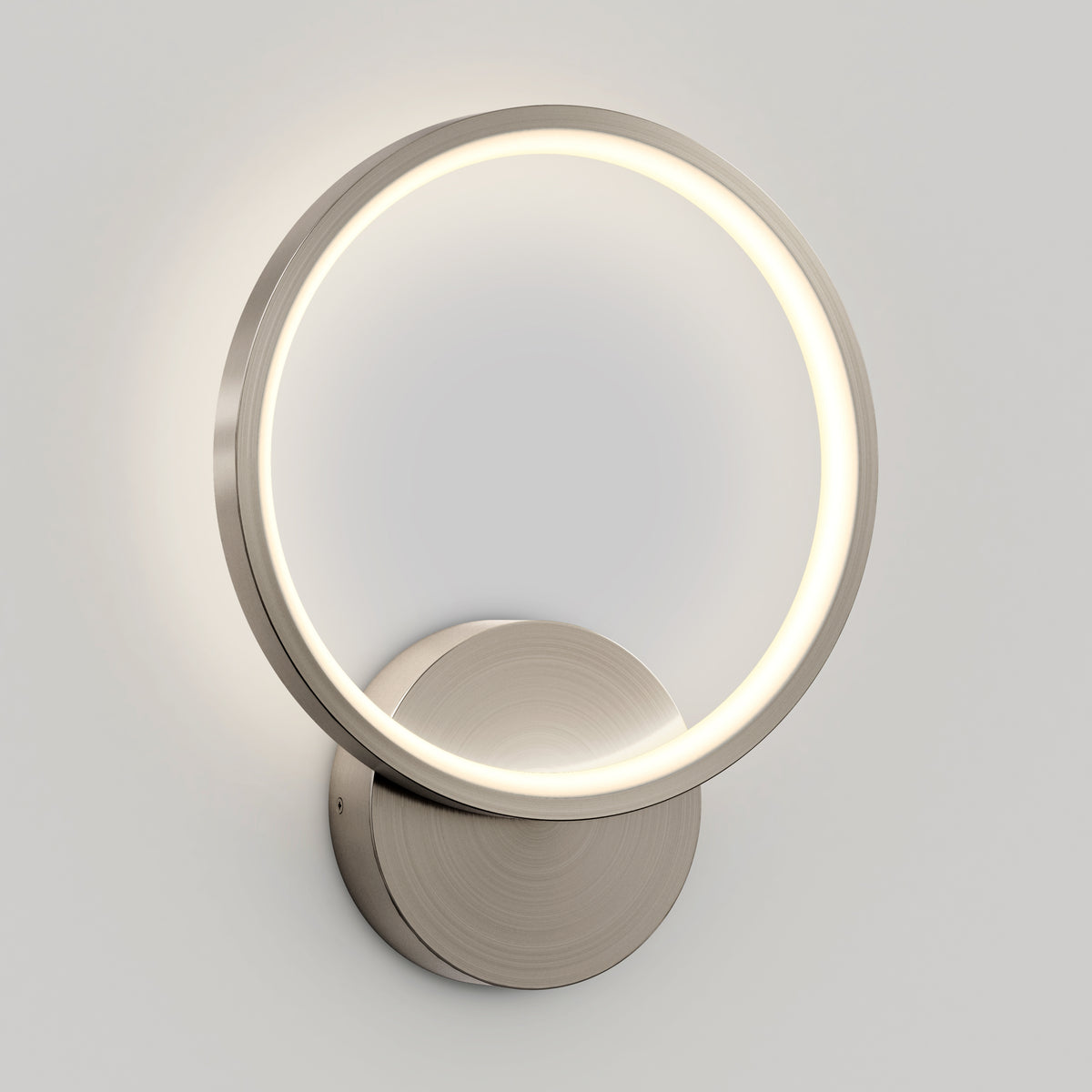 The Artika Solis modern LED indoor-outdoor wall light 5 CCT features a circular brushed metal frame with an integrated LED ring and round base—perfect for accent lighting in contemporary spaces.