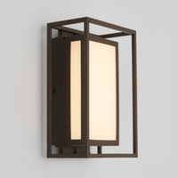 The Artika Ghost indoor-outdoor LED wall light features a modern design with a rectangular frosted glass shade set in a dark metal frame, mounted on a white wall.