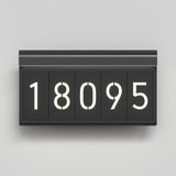 A modern, rectangular black flip clock displaying the number 18095 in white illuminated digits against a light gray background.