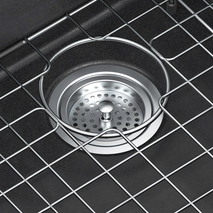 Close-up of Artika’s Baycrest 31 in. Modern Sink drain with removable strainer and grid rack above the black drain opening.