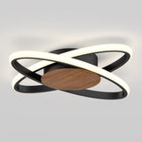 A modern ceiling light fixture with two intersecting black rings containing LED lights, attached to a circular wooden base, mounted on a light gray ceiling.