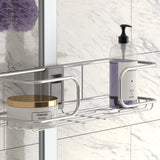 A metal shower shelf holds a round container labeled Hydration Treatment and a pump bottle labeled Soft & Shine Shampoo, against a white and gray marble tiled wall. A purple shower puff hangs in the background.
