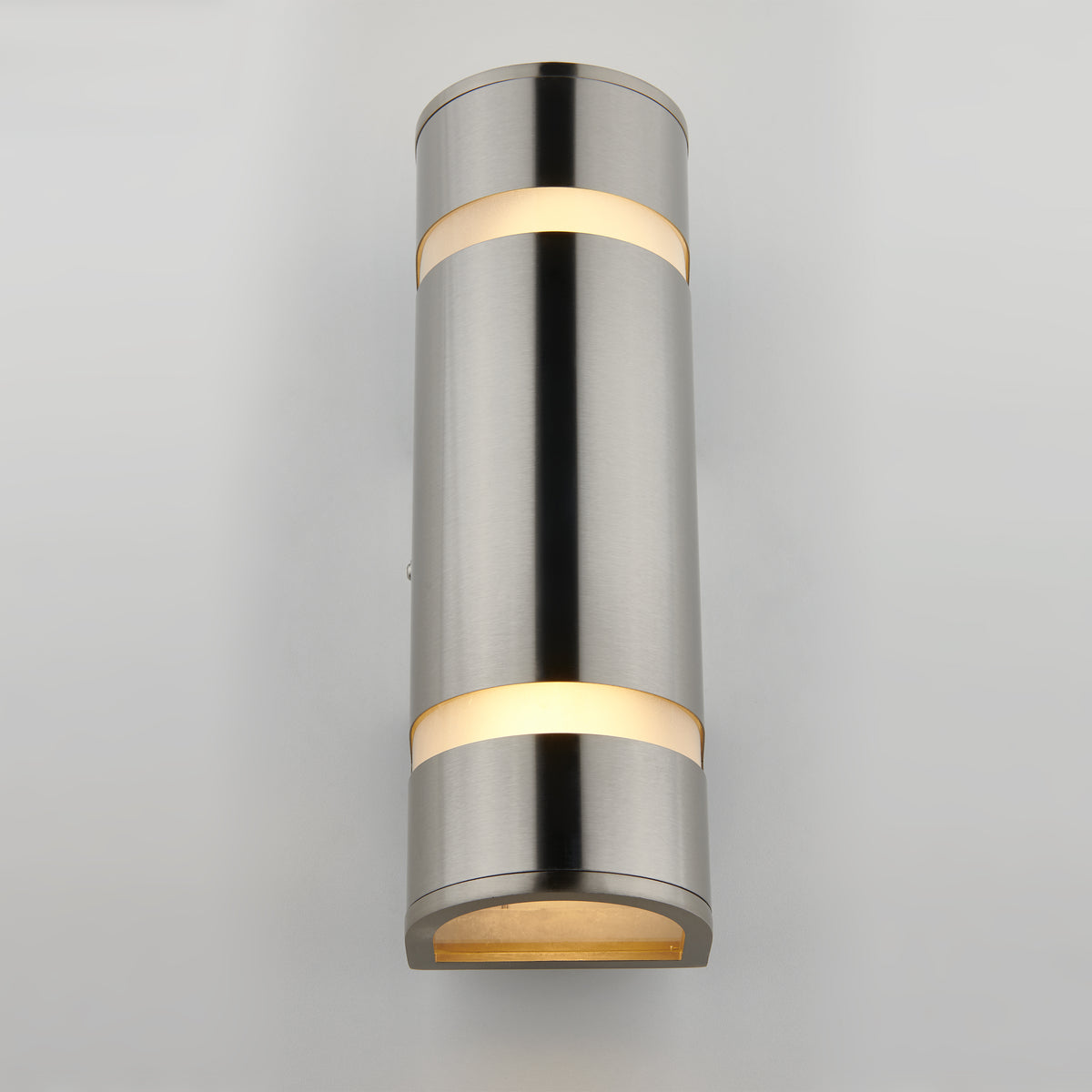 A modern cylindrical wall sconce light made of brushed metal with illuminated bands at the top, middle, and bottom, mounted on a light gray wall.