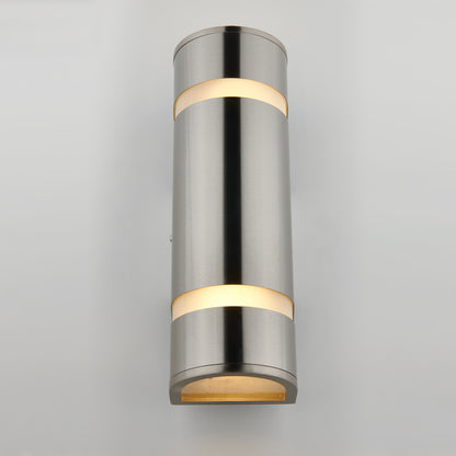 The Artika Q1 indoor-outdoor wall light is a modern cylindrical sconce with a brushed metal finish, casting warm light from the top, middle, and bottom, shown here mounted on a light gray wall.