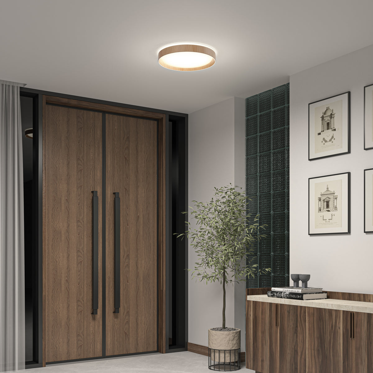 A modern entryway with large wooden double doors, a potted plant, framed art, a wooden console table with decor, and the Artika Callisto 15 in. LED flush mount light for bright, stylish overhead lighting.