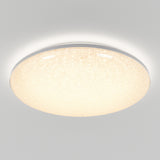 A round, flush-mounted ceiling light fixture with a glowing, textured surface emits soft, warm light against a plain white ceiling.