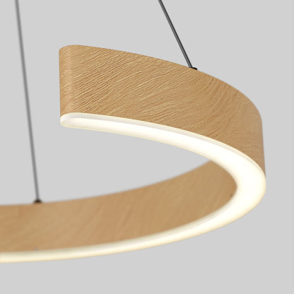 A close-up of the Artika-CAN-dev Vance modern LED pendant light 3 CCT, featuring a circular design, wood-textured finish, and slim black suspension cables set against a plain gray background.