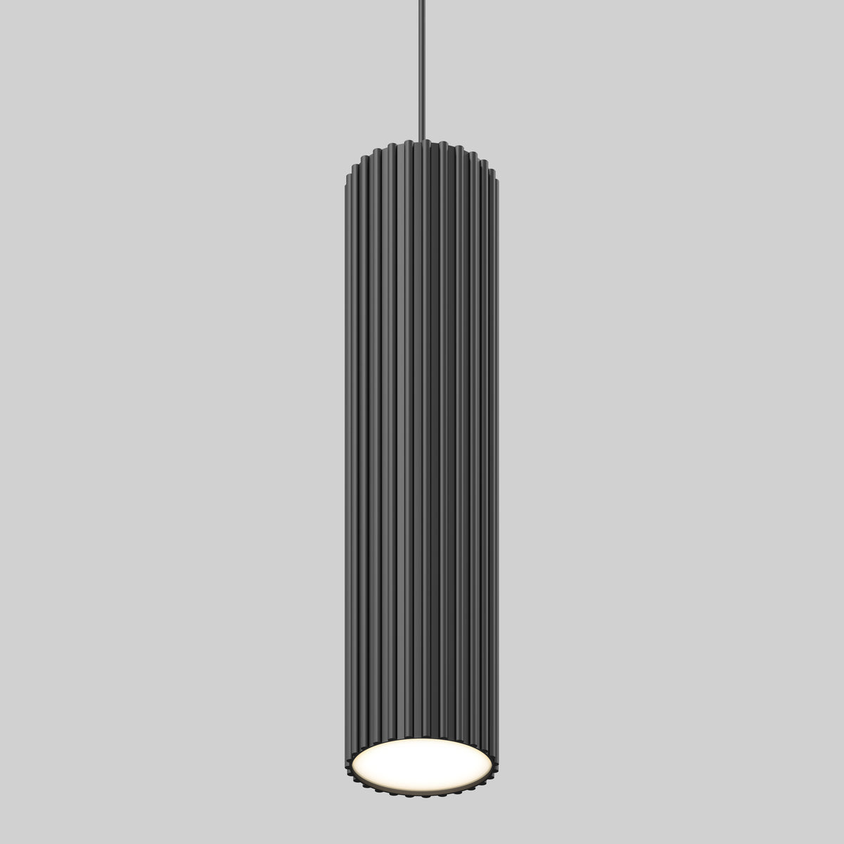 A modern, cylindrical black pendant light with vertical grooves hangs from the ceiling against a plain gray background. The bottom of the light is open, emitting a soft white glow.