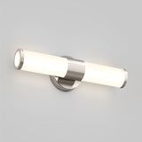 A modern wall-mounted LED light fixture with a cylindrical frosted glass shade and brushed metal accents, emitting soft white light against a plain light gray wall.