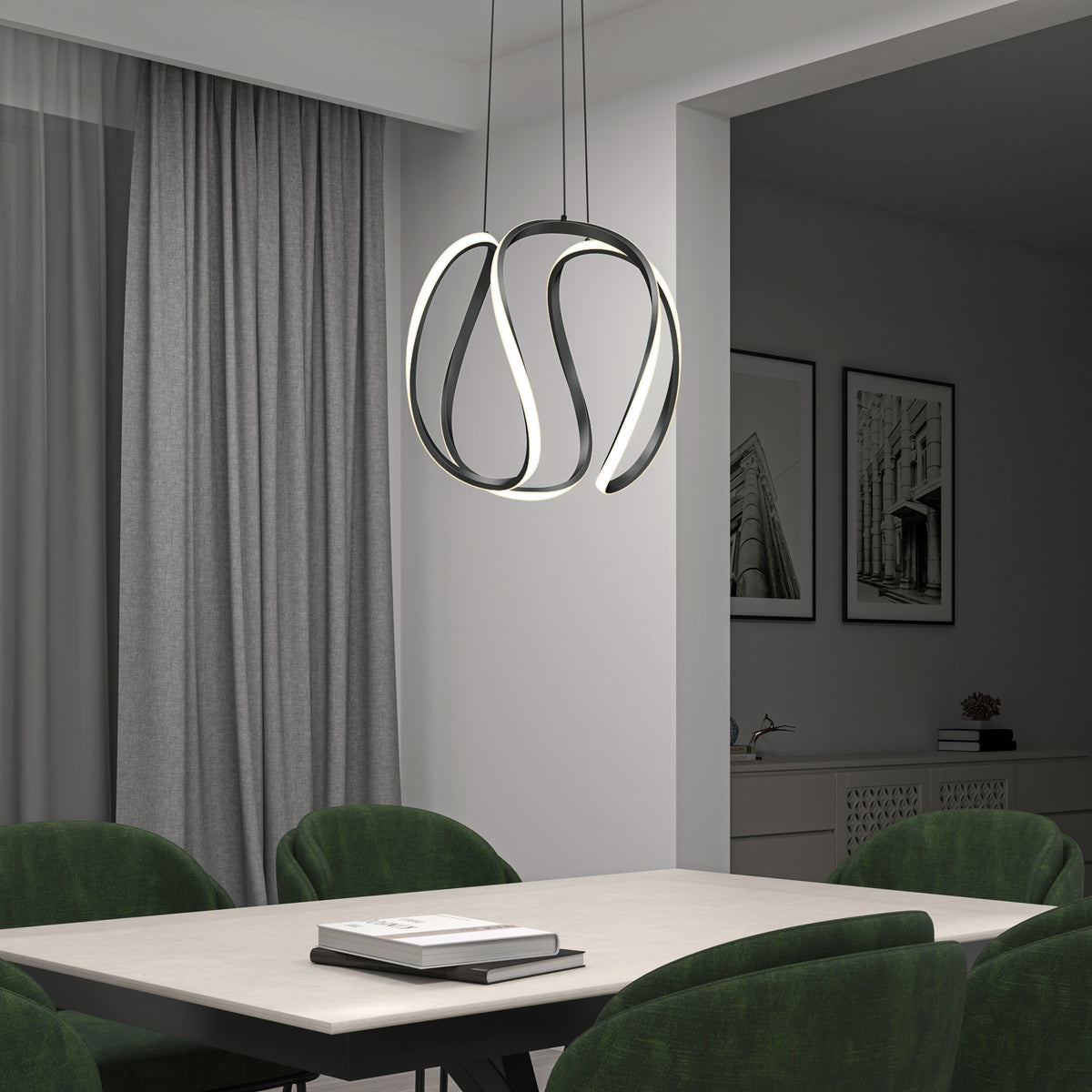 A modern dining room with a white table, green upholstered chairs, and a sculptural, loop-shaped pendant light. Gray curtains and framed architectural photos decorate the neutral-toned space.