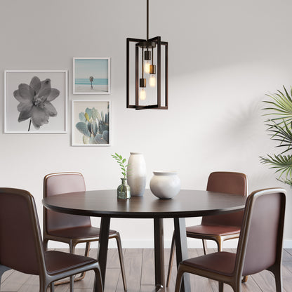 A modern dining room featuring a round dark wood table, four brown chairs, three ceramic vases, wall art, an Artika Yale 3-light Chandelier, wood floors, and a tall green plant in the corner.