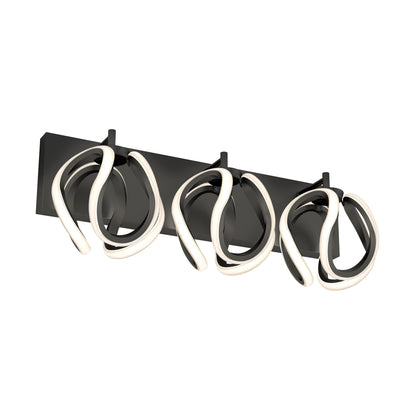 The Artika Vivaldi LED contemporary bathroom vanity light features three sculptural looped elements with sleek black exteriors, glowing white inner edges, and a rectangular black base. Offers 3 CCT settings for customizable lighting.