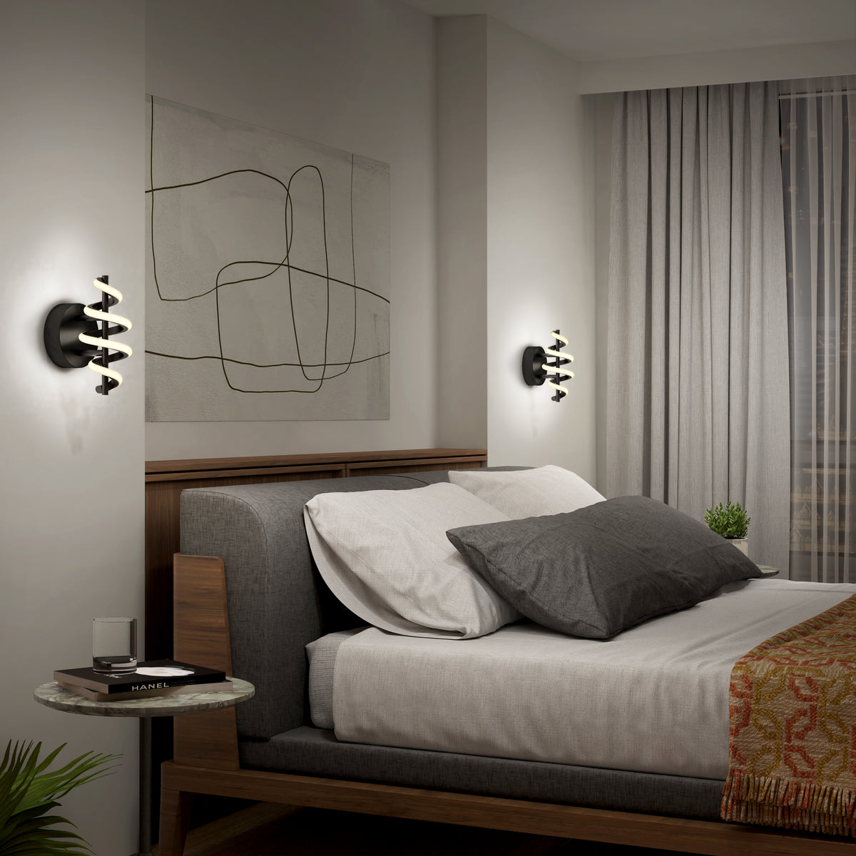 Modern bedroom with a wooden bed, gray and white bedding, abstract wall art, round side table, wall-mounted lights, and sheer curtains over a window. A small plant and books sit on the side table.