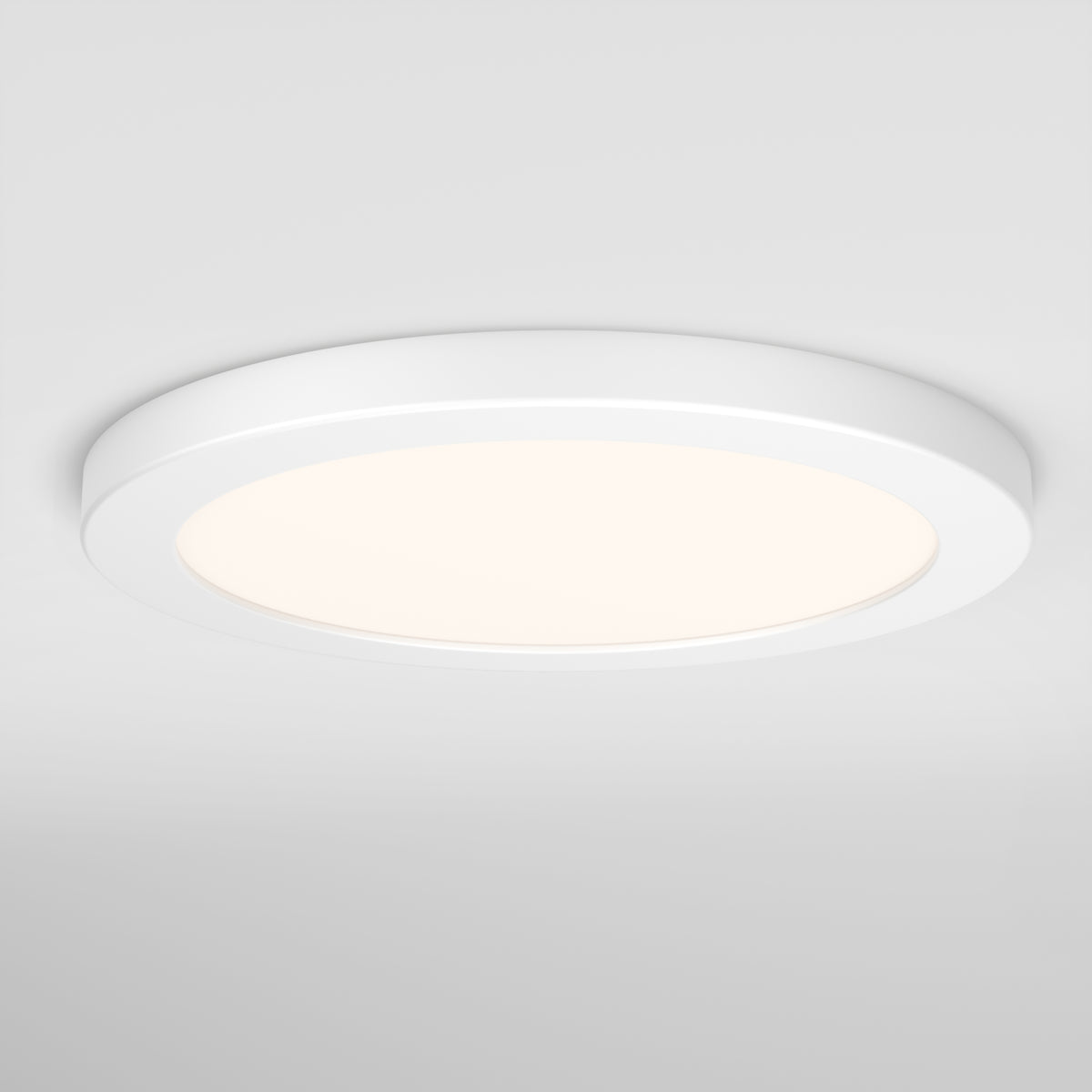 A round, modern, white ceiling light fixture is mounted on a white ceiling, emitting a soft, even glow.