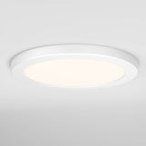 A round, modern, white ceiling light fixture is mounted on a white ceiling, emitting a soft, even glow.
