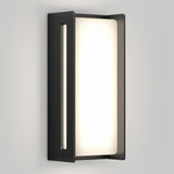 A modern wall sconce with a rectangular black metal frame and a frosted white light panel emits a soft, even glow against a light gray wall.