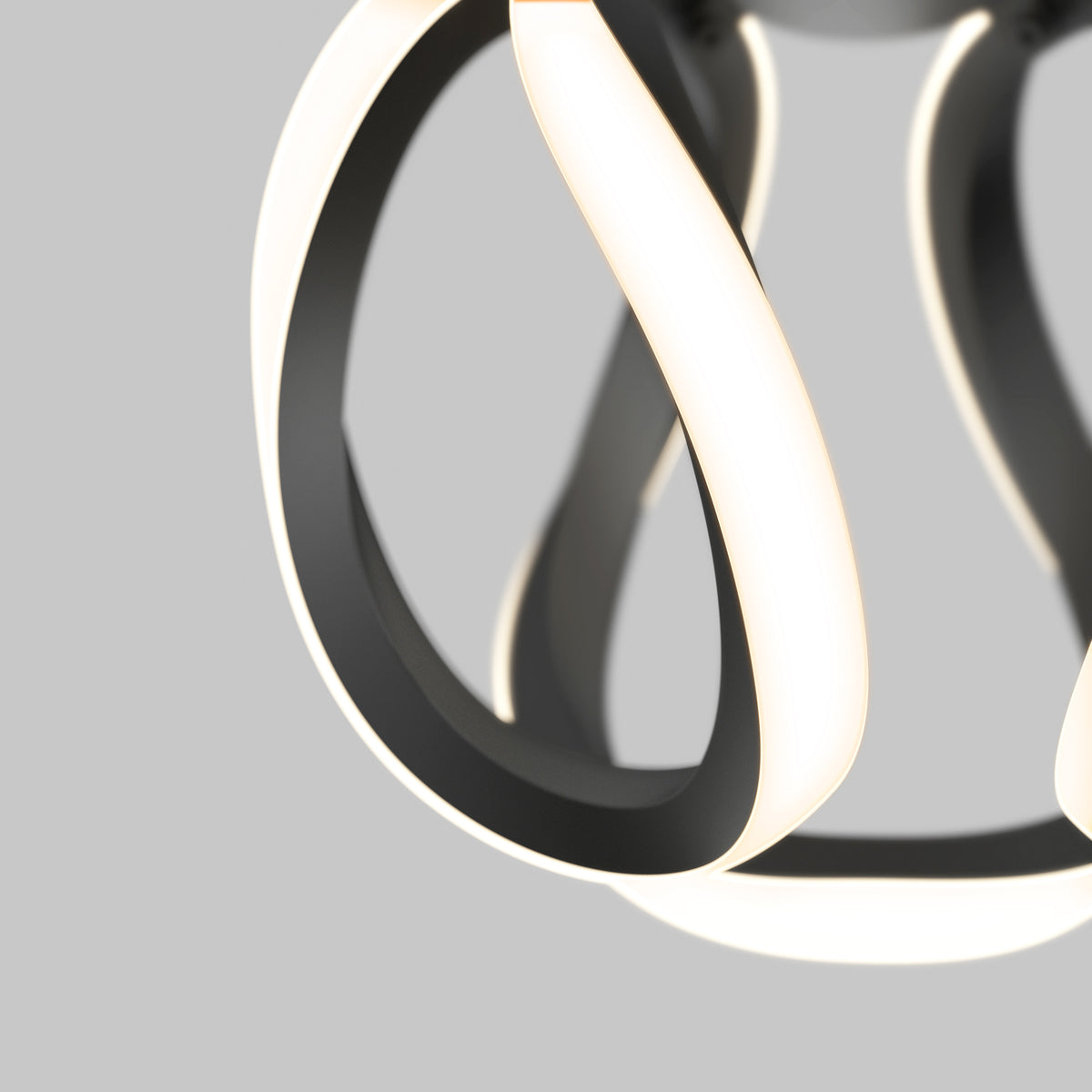 Close-up of a modern, abstract LED light fixture with smooth, curved black and white bands, softly glowing against a neutral background.