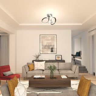 Modern living room featuring Artika’s Swirl LED flush mount (1300 lumens), grey sofa, vibrant cushions, and abstract art.