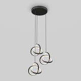 Modern ceiling pendant light with three hanging loops of black and white LED rings, suspended at varying heights from a round black base against a light gray background.