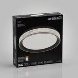 A black rectangular box for an Artika Aston LED flush mount light, featuring an image of the round light fixture on the front and product details like lifespan, wattage, and brightness on a gray background.