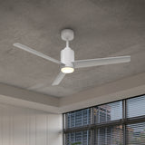 A modern white ceiling fan with three blades and an integrated light is mounted on a gray ceiling in a room with large windows and horizontal blinds.