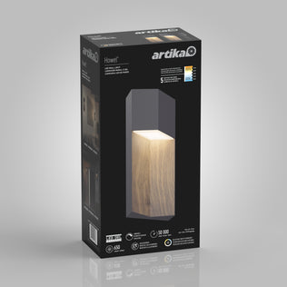 A black Artika box for the Howel modern LED indoor-outdoor wall light 5 CCT shows a glowing wood-textured rectangular fixture on the front, along with its brightness, energy savings, and lifespan details.