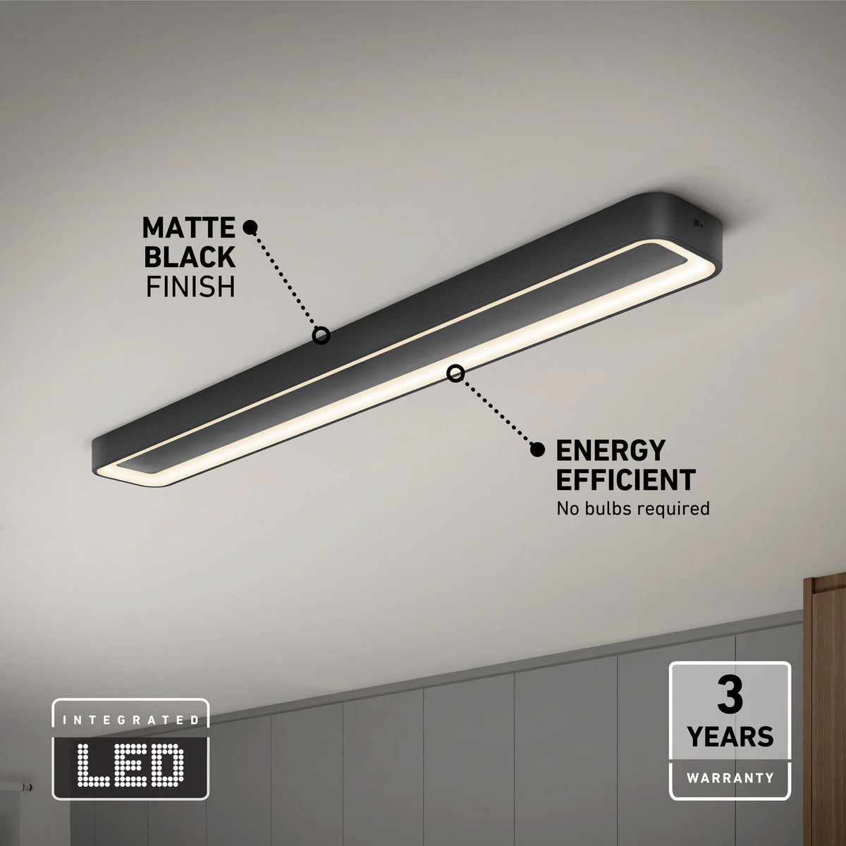 The Artika Aiden 48 in. LED modern flush mount light 5 CCT, with a matte black finish and energy-efficient integrated LED, is mounted on a white ceiling above gray cabinets and comes with a 3-year warranty.