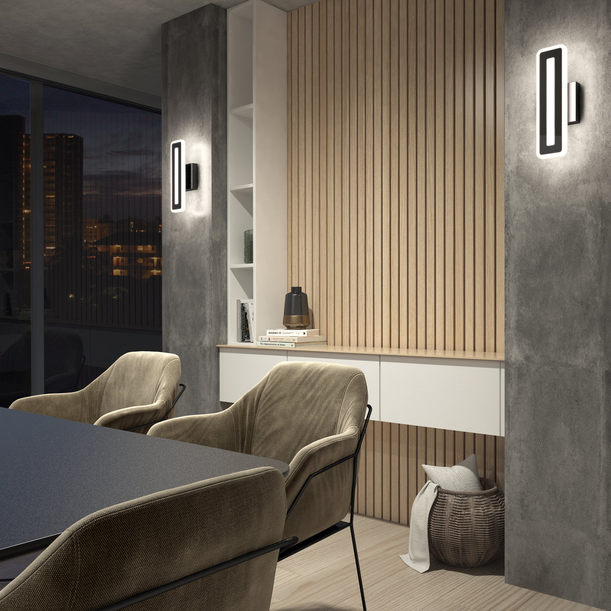 Modern office with beige armchairs, a dark table, vertical wooden slat wall, built-in shelves, soft lighting from sleek rectangular wall sconces, a basket with a blanket below drawers, and cityscape visible through large windows at night.