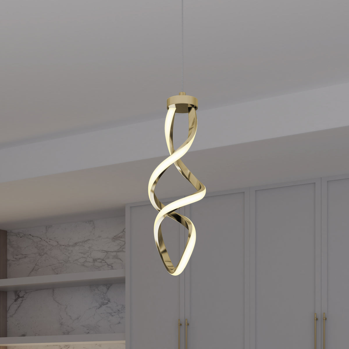 The Artika Mini Swirl LED pendant light, featuring a twisted ribbon-like design in gold, hangs from the ceiling of a minimalist room with light gray cabinets and marble-patterned walls.